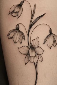 a black and white tattoo with flowers on the side of a woman's thigh