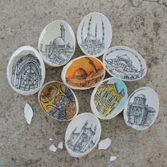 six ceramic plates with designs on them sitting on the ground in front of a building