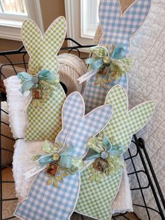 three decorative easter bunnies sitting on top of each other in front of a window