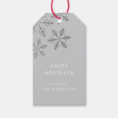 a christmas gift tag with snowflakes on it and the words happy holidays written in white