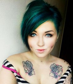 a woman with green hair and tattoos on her chest