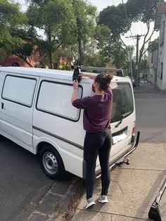 a woman is taking a picture of herself in front of her van