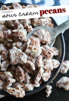 a bowl full of sour cream pecans on top of a table with a spoon