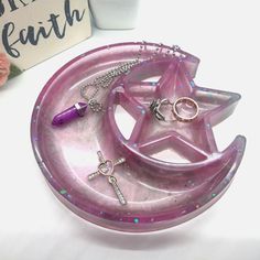 a star and moon shaped tray with rings on it next to a sign that says faith