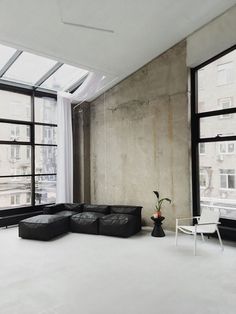 a living room filled with furniture and large windows next to a white flooring area