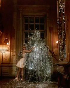 a woman standing in front of a fountain filled with water