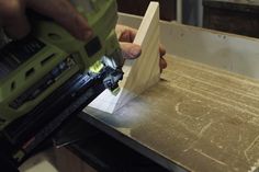 a person using a power tool on a piece of wood