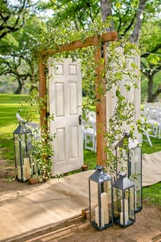 an outdoor ceremony set up with lanterns and greenery