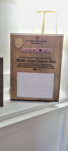 an award plaque sitting on top of a white shelf next to a brown paper bag