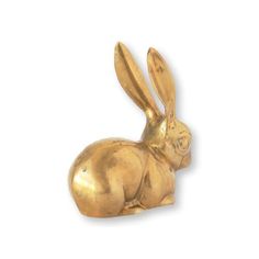 a gold colored rabbit figurine on a white background