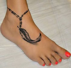 a woman's foot with a black and white feather tattoo on the bottom of it