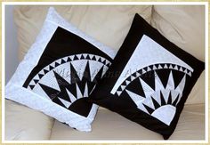 two black and white pillows sitting on top of a couch