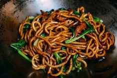 a bowl filled with noodles and vegetables on top of a table