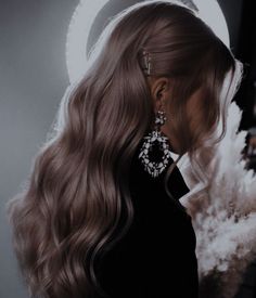 a woman with long blonde hair wearing earrings