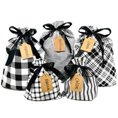 four black and white checkered bags with tags hanging from the top, each containing a name tag