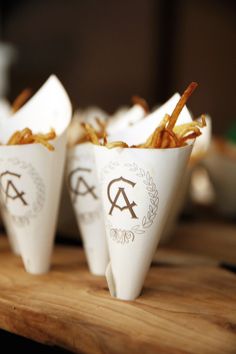 three small cones filled with food on top of a wooden table