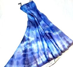 a blue dress is hanging on a clothes hanger and it looks like tie - dye