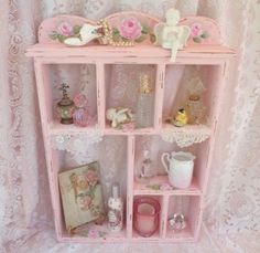 a pink dollhouse shelf with many items on it