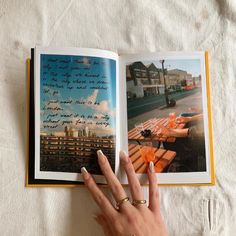 a woman's hand is holding an open book