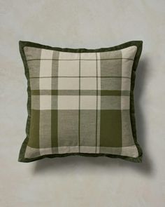 a green and white plaid pillow sitting on top of a wall