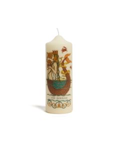 a white candle with an image of a ship on the front and side, sitting in front of a white background