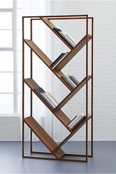 a bookshelf that is standing in front of a white brick wall and window