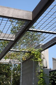 an outdoor area with a metal structure and plants hanging from it's side wall