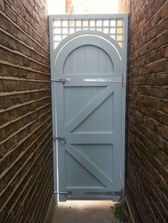 an open door leading to a brick wall with a gate on one side and another in the other