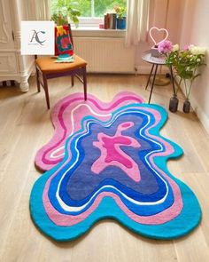 a living room with wooden floors and colorful rugs on the floor in front of a window