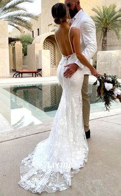 a man and woman standing next to each other in front of a pool