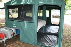 a tent that is in the grass with its door open and windows opened to let people inside