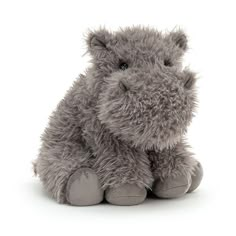 a gray stuffed animal sitting on top of a white floor