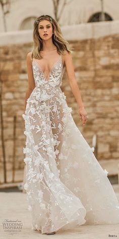 a woman in a white wedding dress with flowers on the skirt and her hair pulled back