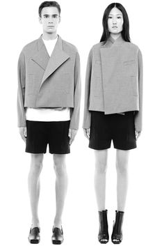 two people standing next to each other in black and white outfits, both wearing short shorts