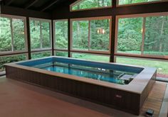 an indoor jacuzzi tub in the middle of a room with large windows on both sides