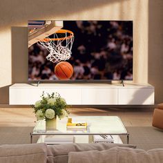 a basketball going through the hoop in front of a large screen tv on a wall