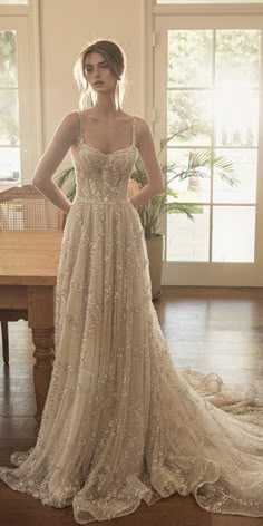 a woman standing in front of a table wearing a dress with sequins on it