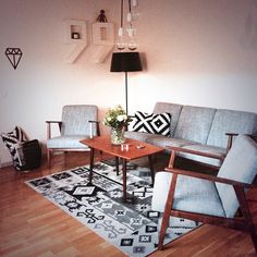 a living room with two couches and a coffee table on top of a rug