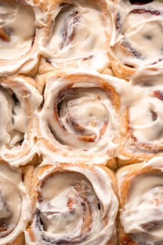 cinnamon rolls with icing sitting on top of each other