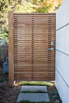 a wooden slatted door is open in the yard