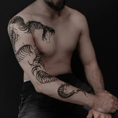 a man with a horse tattoo on his arm sitting down and looking at the camera