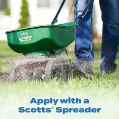 a man mowing the grass with a green lawnmower and text that reads, apply with a scotts spreader