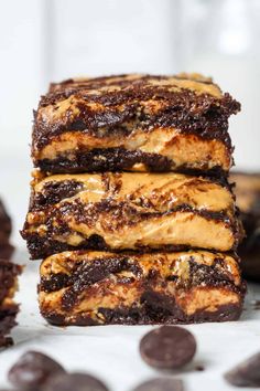 three pieces of chocolate peanut butter brownie stacked on top of each other with one bite taken out