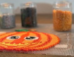 a close up of a piece of art made out of beads on a wooden table