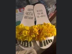 two pairs of white sandals with yellow flowers on the bottom and happy birthday written on them