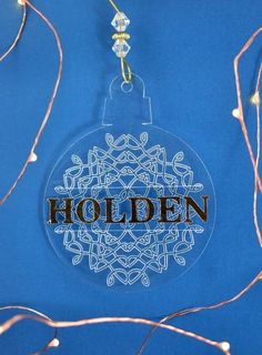 a glass ornament with the word holder on it and some lights around it