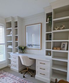 a white desk sitting in front of a window next to a book shelf filled with books