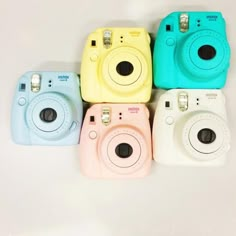 four different colored cameras sitting next to each other