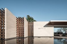 an architecturally designed building with water in the foreground