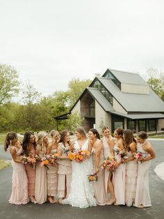 a group of women standing next to each other in front of a building with flowers